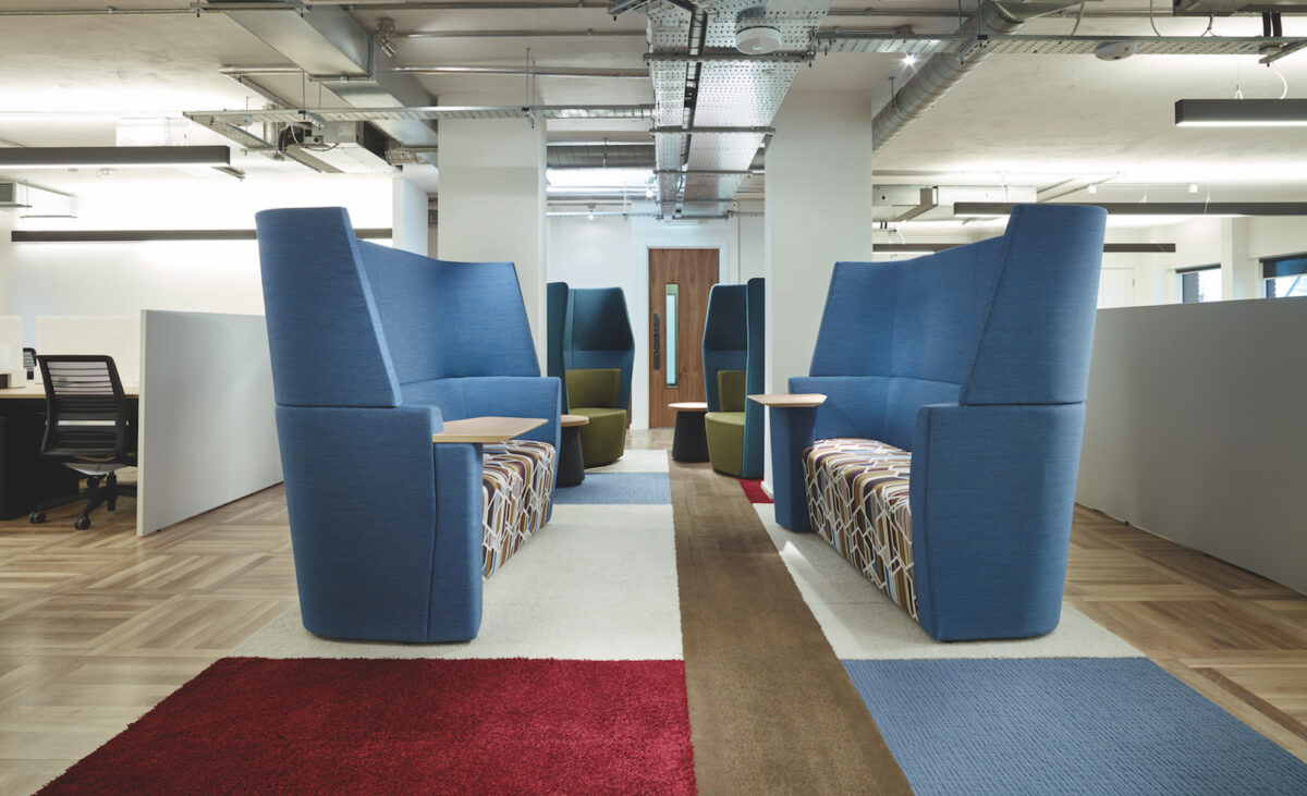 Us&Co London office workspace with modern shared facility. Featuring multiple seater lounge in blue with small side tables.