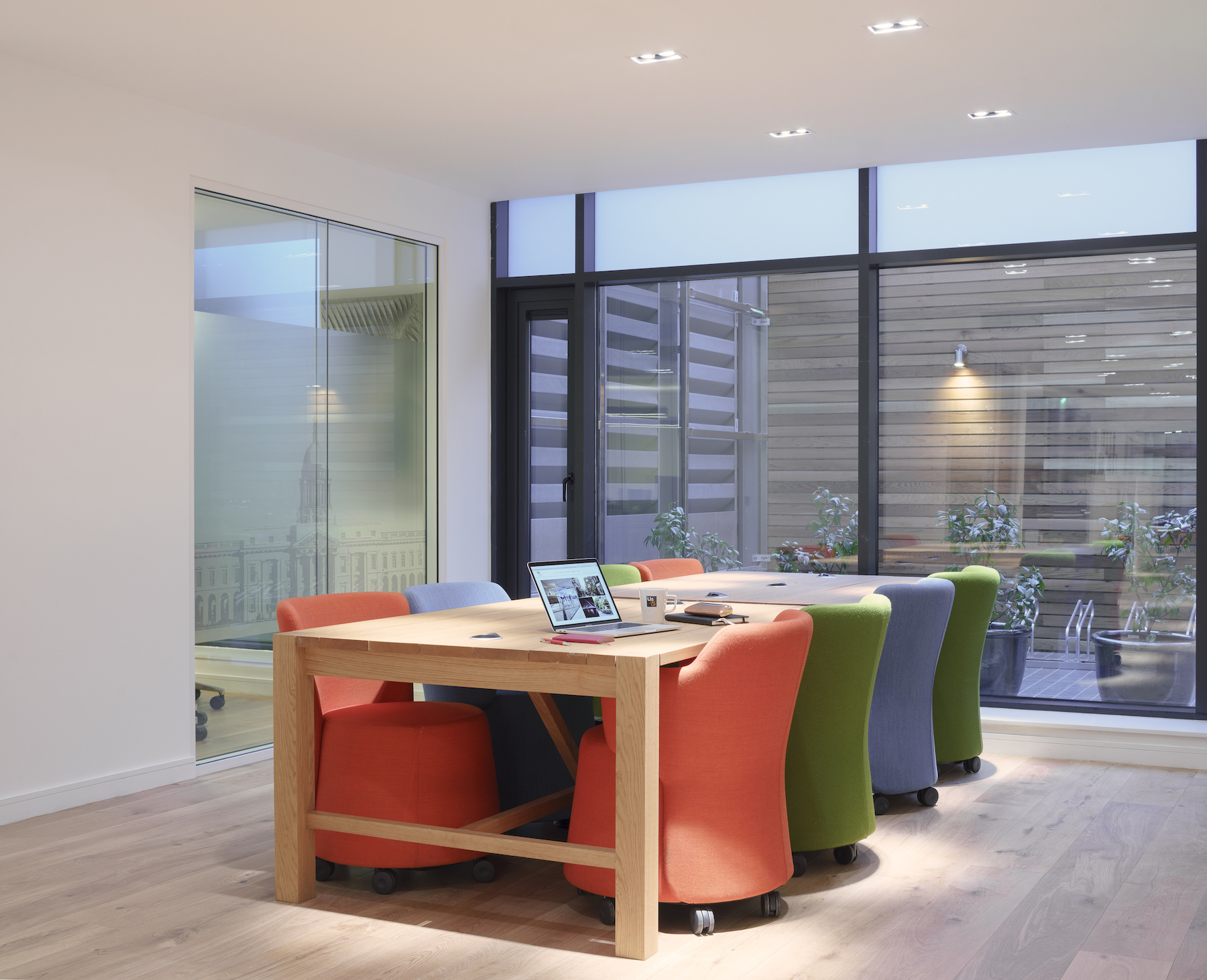Hot desk rental in Dublin, featuring flexible shared office space with long wooden table and colourful chairs