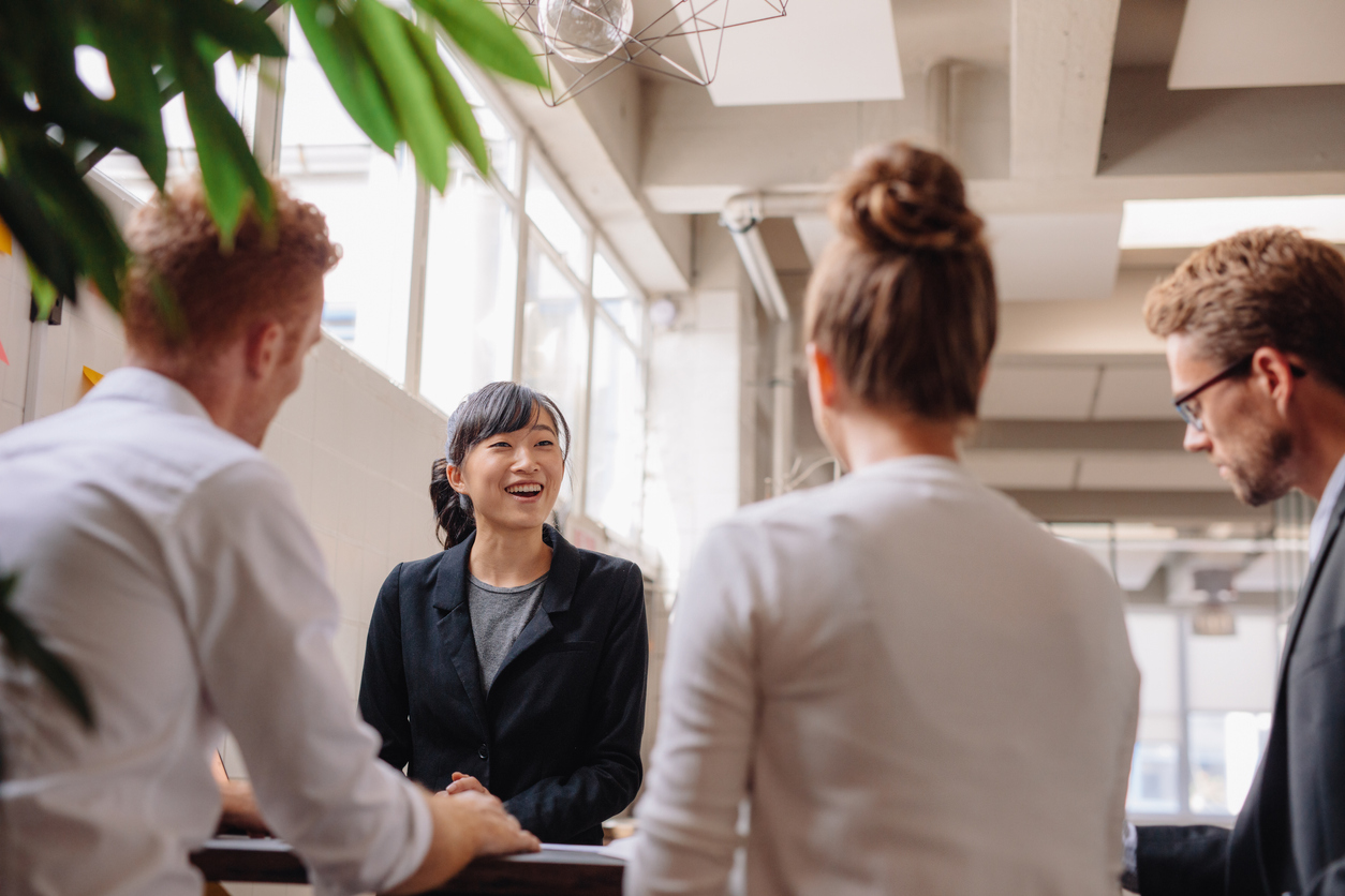 Team hosting a standing meeting around an elevated desk